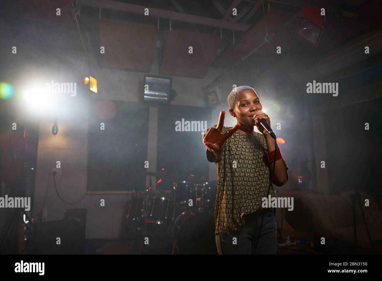 Portrait coole Musikerin singt und gestikuliert Friedenszeichen Stockfoto