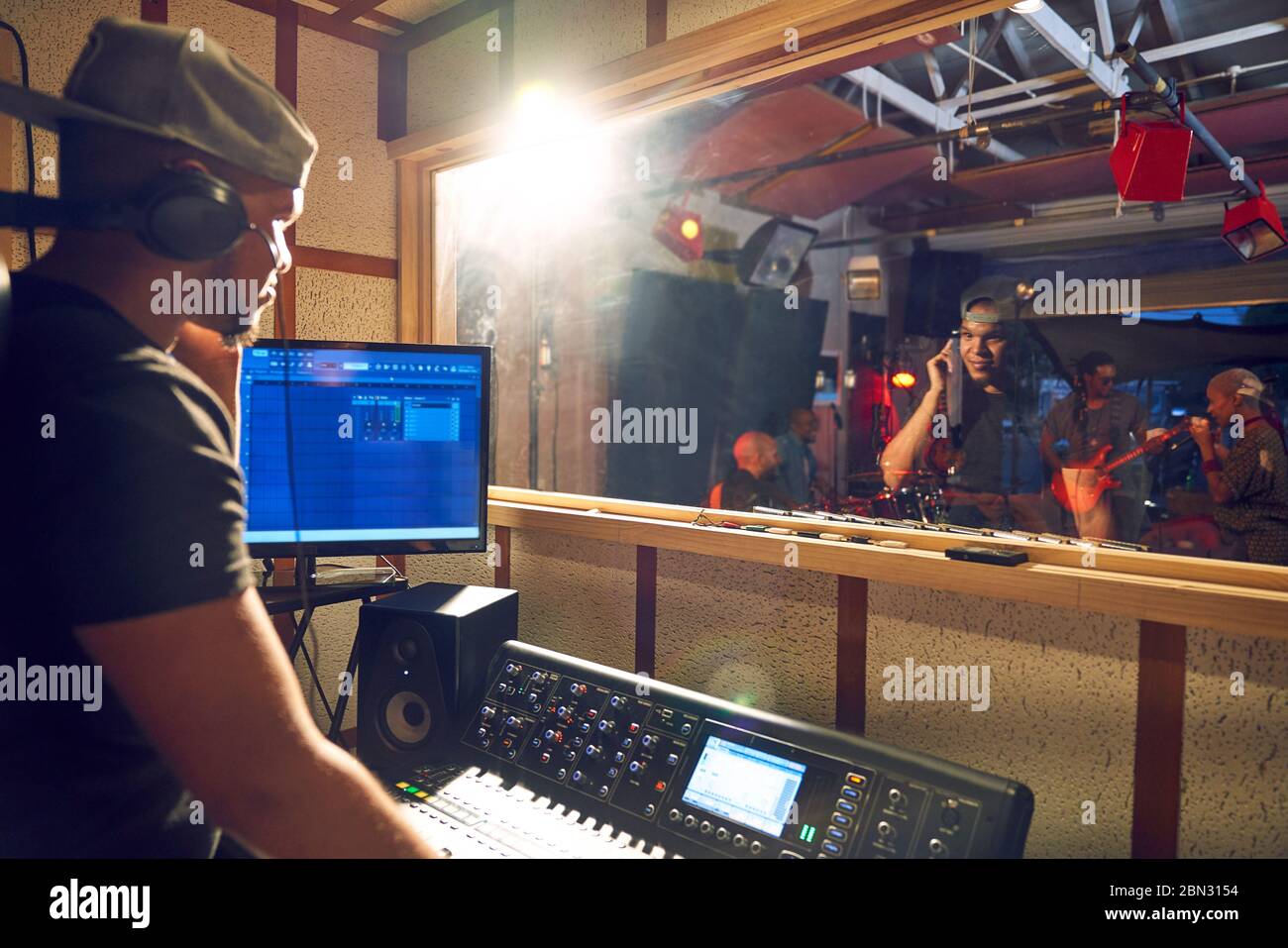 Männlicher Musikproduzent am Soundboard im Tonstudio Stockfoto