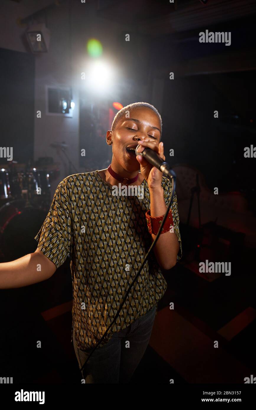 Musikerin singt ins Mikrofon im Aufnahmestudio Stockfoto