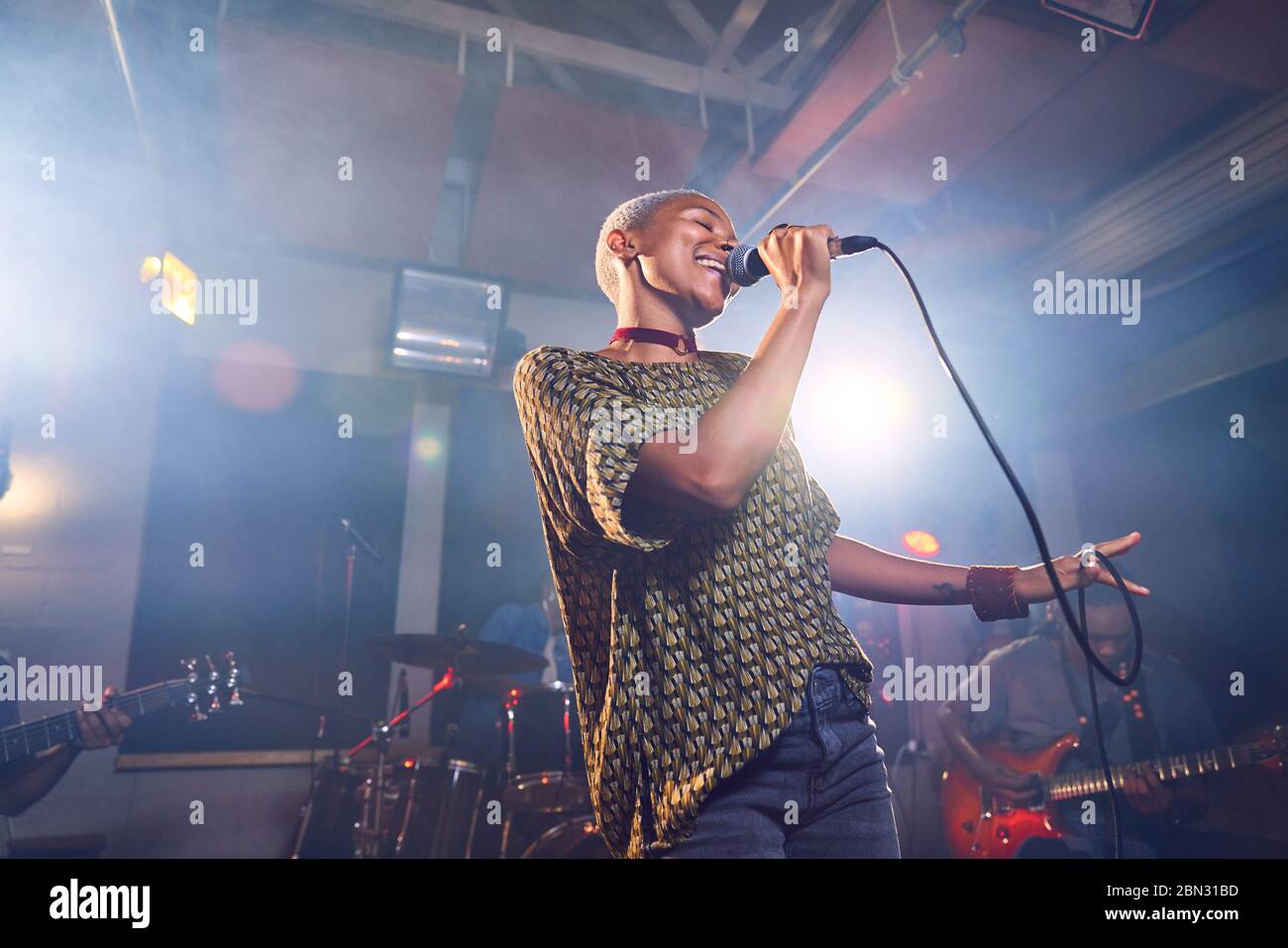 Musikerin singt ins Mikrofon im Aufnahmestudio Stockfoto