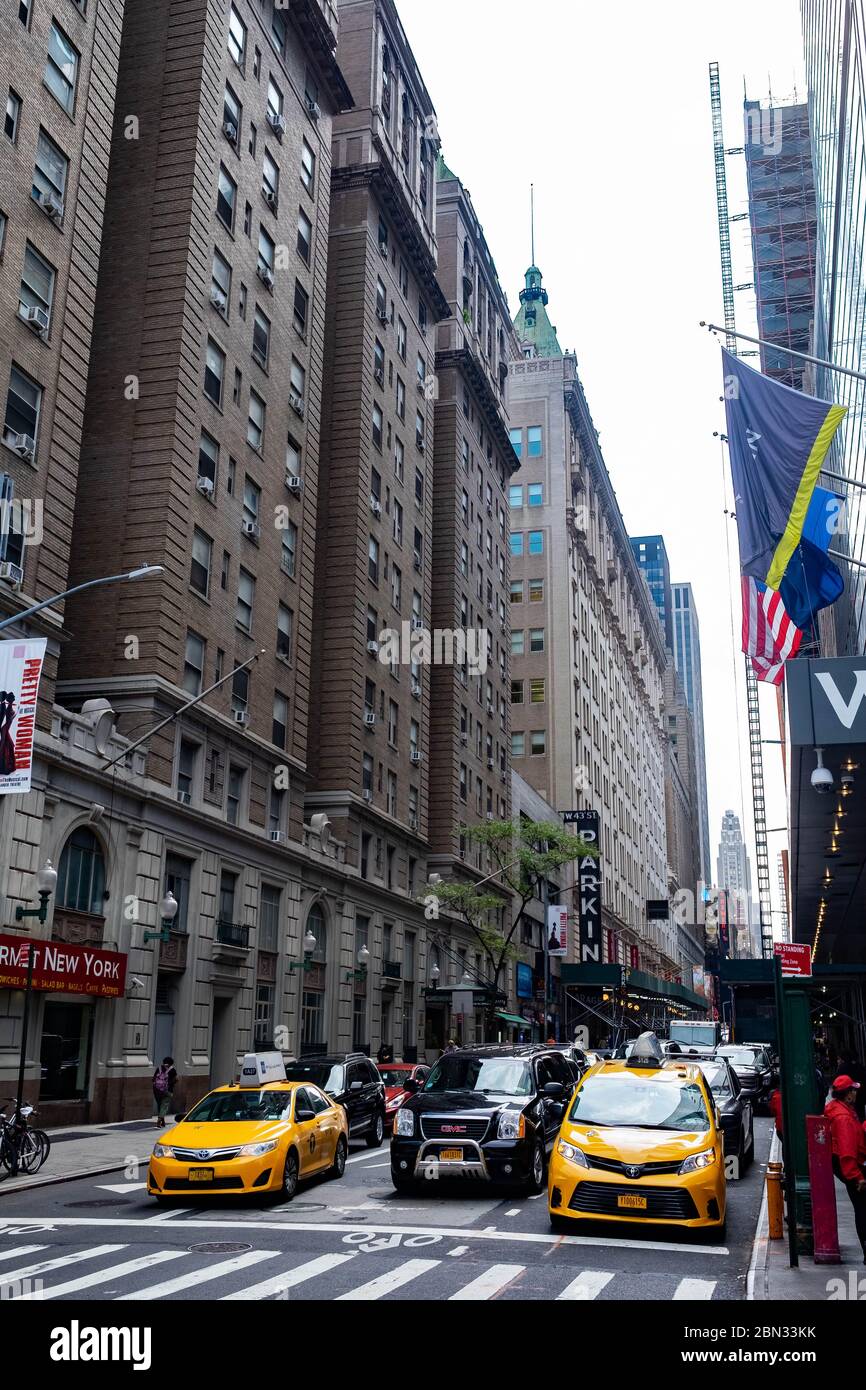 Die belebten Straßen des Times Square in Midtown Manhattan, New York, einschließlich der berühmten gelben Taxis, die stark frequentiert sind Stockfoto