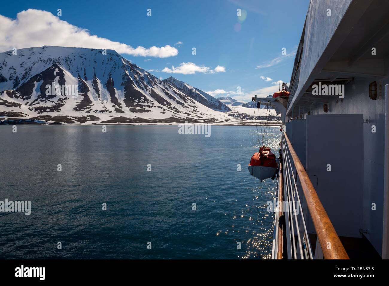 Das orangefarbene Rettungsboot in arktischen Gewässern, Spitzbergen, ins Wasser lassen. Schiffsangebohrung abbrechen. Rettungsboot-Training. Mann über Bord Bohrer. Stockfoto