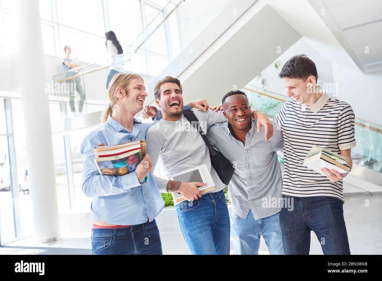 Glückliche Studenten lachen gemeinsam als Team in der Universität Stockfoto