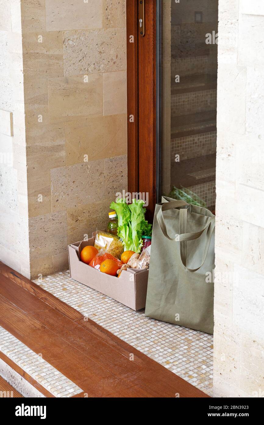 Lebensmittelzustellung oder Spende Box während covid Quarantäne. Kontaktlose soziale Heimlieferung sicheres Einkaufen bei Coronavirus-Pandemie. Essen zum Mitnehmen. Lebensmittelbox Stockfoto