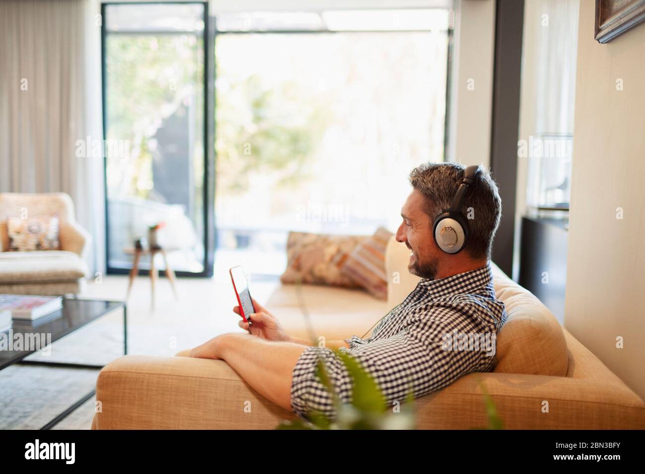 Mann mit Kopfhörer und mp3-Player, der Musik zu Hause hört Stockfoto