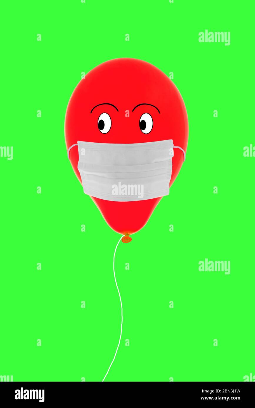 Rot gefärbter Ballon auf grünem Hintergrund mit OP-Maske während der  Coronavirus-Periode Stockfotografie - Alamy