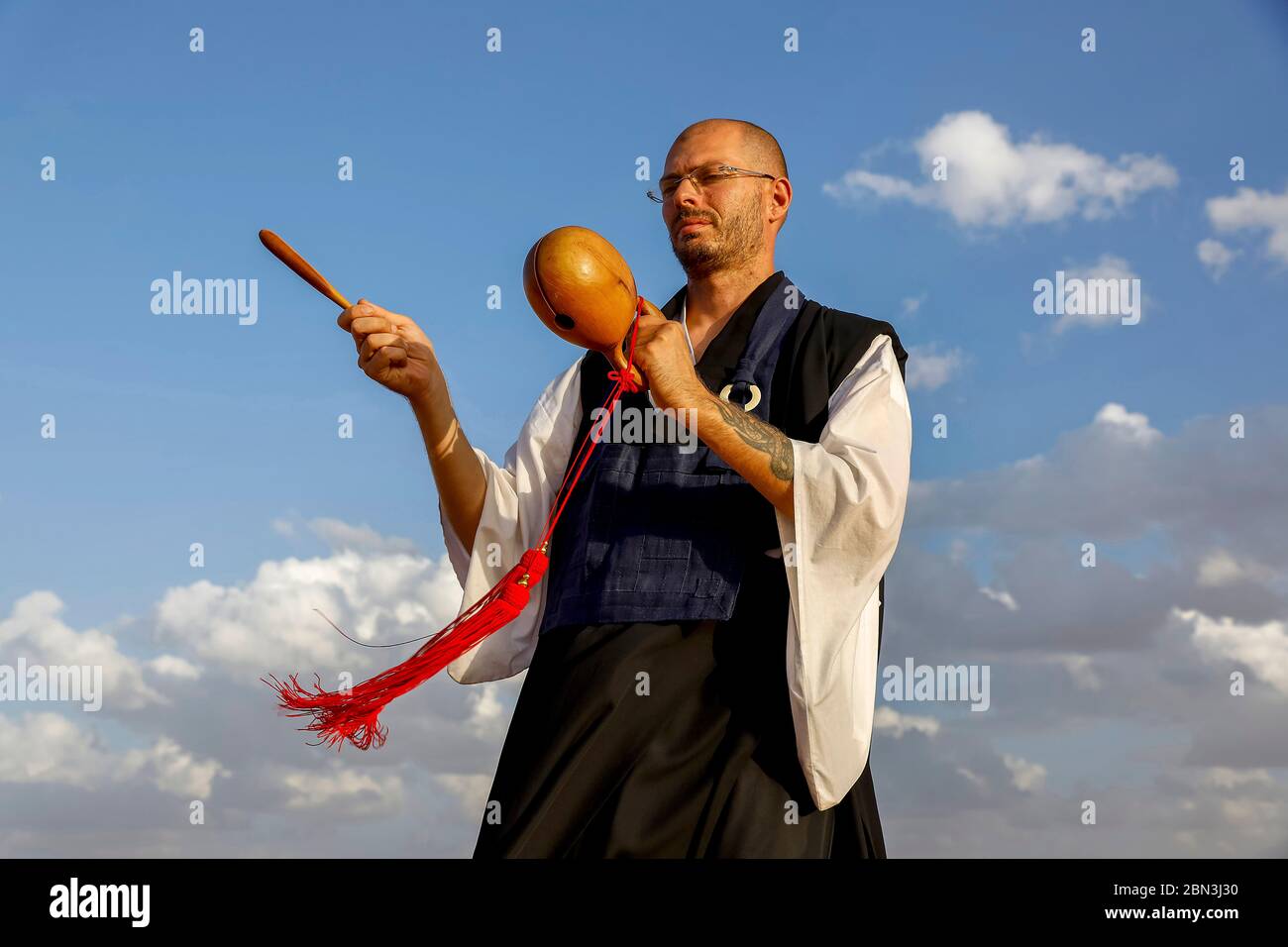 Zen Mönch ruft Praktizierende durch Klopfen auf Holz in Marokko. Stockfoto