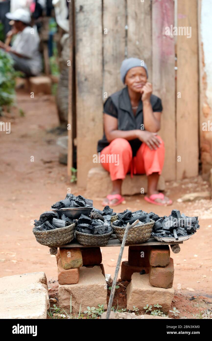 Frau, die Holzkohle auf der Straße verkauft. Madagaskar. Stockfoto