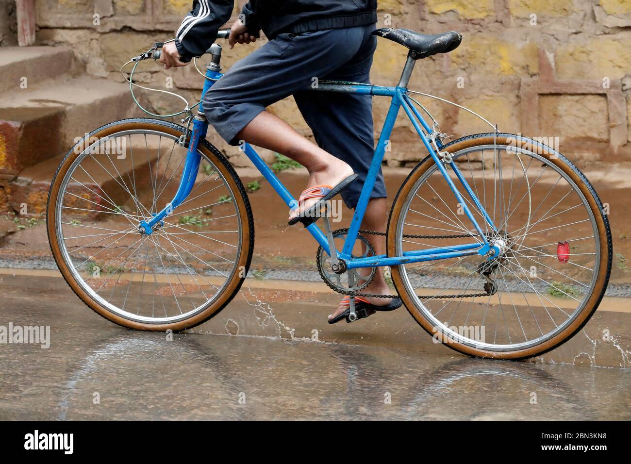 Mann Fahrrad fahren in starkem Regen. Madagaskar. Stockfoto