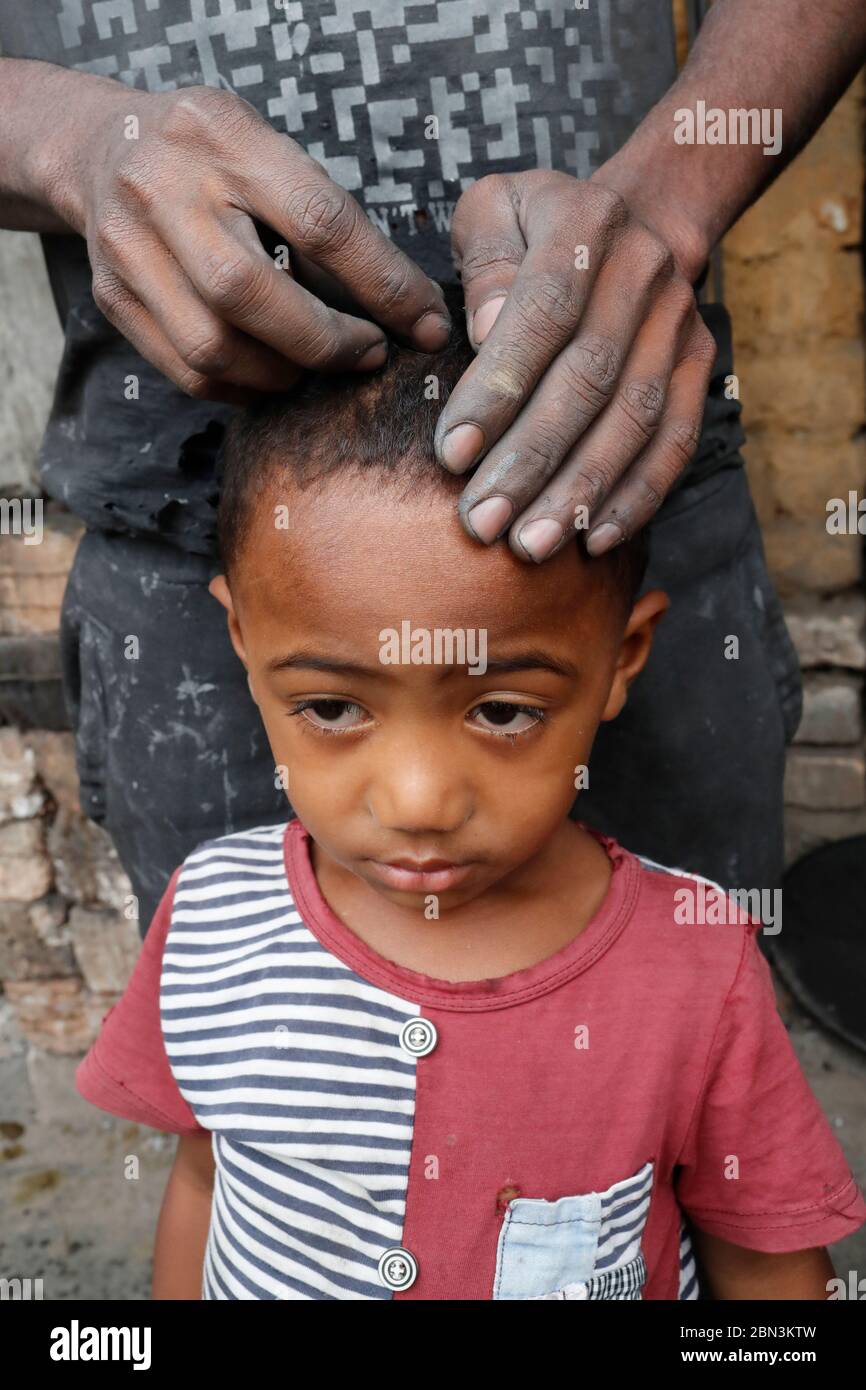 Trauriges madagassy Kind mit ist Vater. Hochformat. Madagaskar. Stockfoto