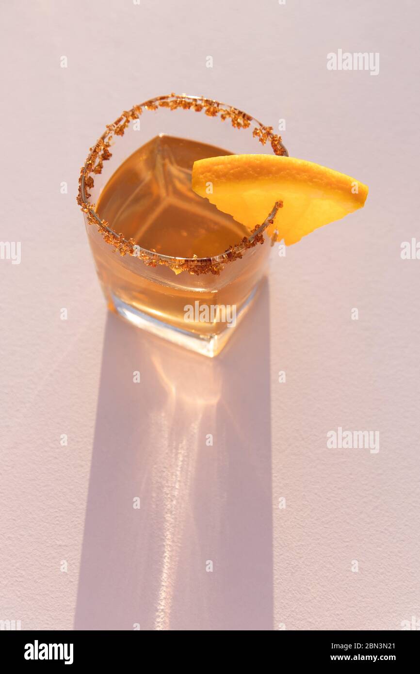 Cocktail, Drink mit Orange isoliert auf hellrosa Hintergrund und hartem Licht, Sommer Sonnenuntergang Party Stockfoto