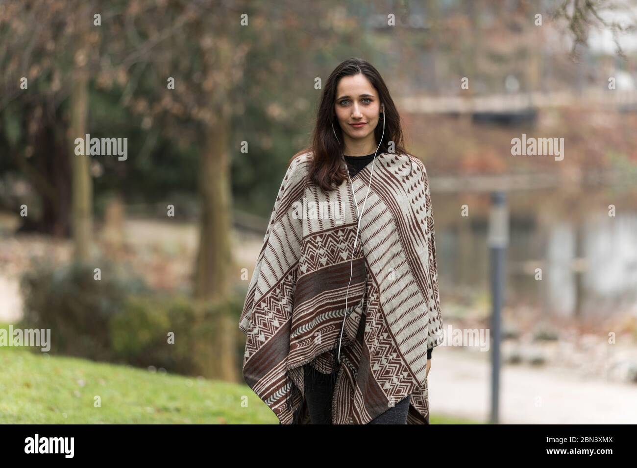 Junge Frau im mittleren Osten modellieren Poncho im öffentlichen Park im Herbst. Stockfoto