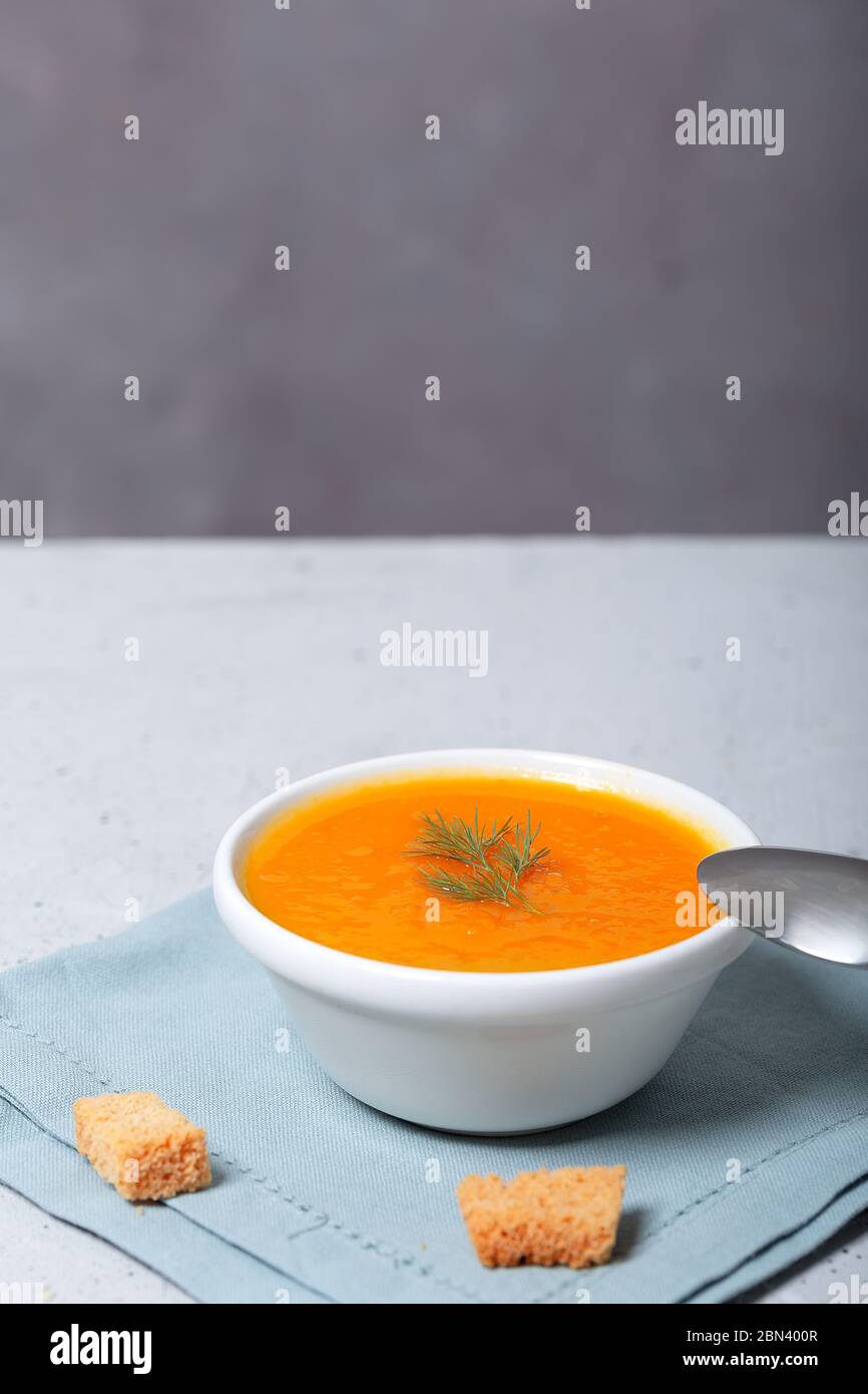 Kürbis- und Karottensuppe mit frischem Dill auf dem Tisch Stockfoto