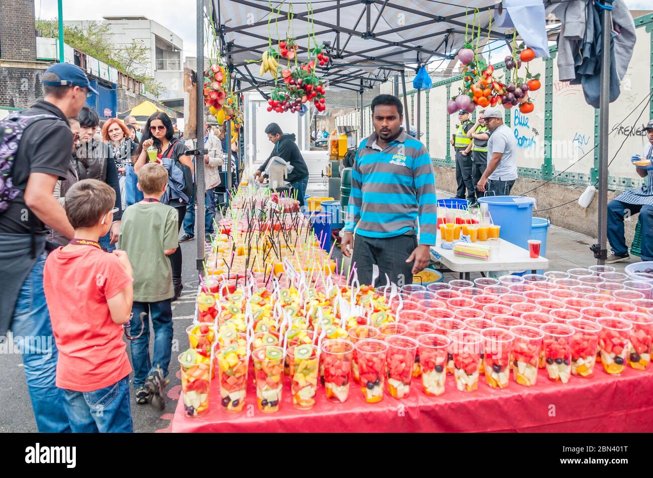 Farbenfroher Street Food-Stand, der Fruchtsaft auf einem Sonntagsmarkt in der Brick Lane in London verkauft Stockfoto