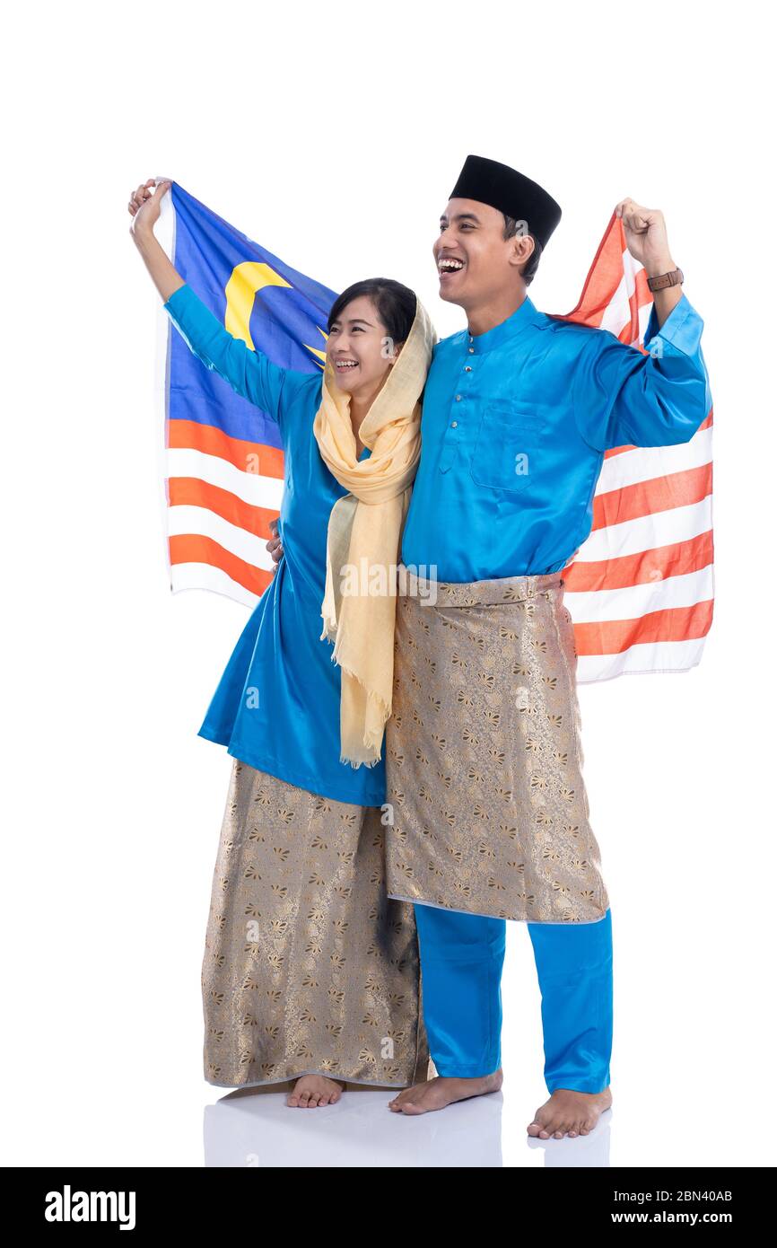 muslimisches Paar trägt traditionelle melayu-Kleidung mit malaysia-Flagge Stockfoto