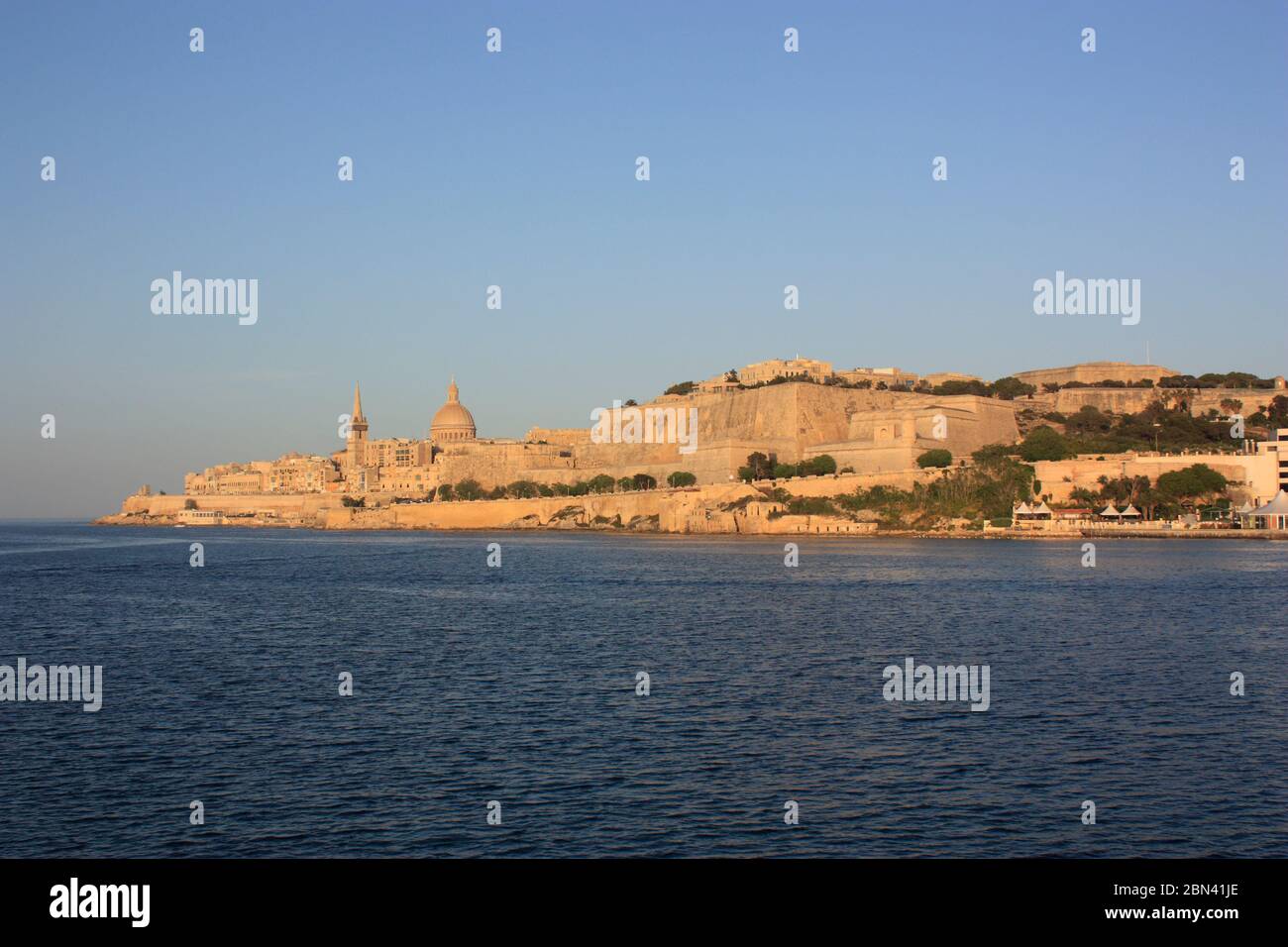 Valletta, Malta, eine historische europäische befestigte Stadt und beliebtes Reiseziel im Mittelmeer, wie von Marsamxett bei Sonnenuntergang gesehen Stockfoto