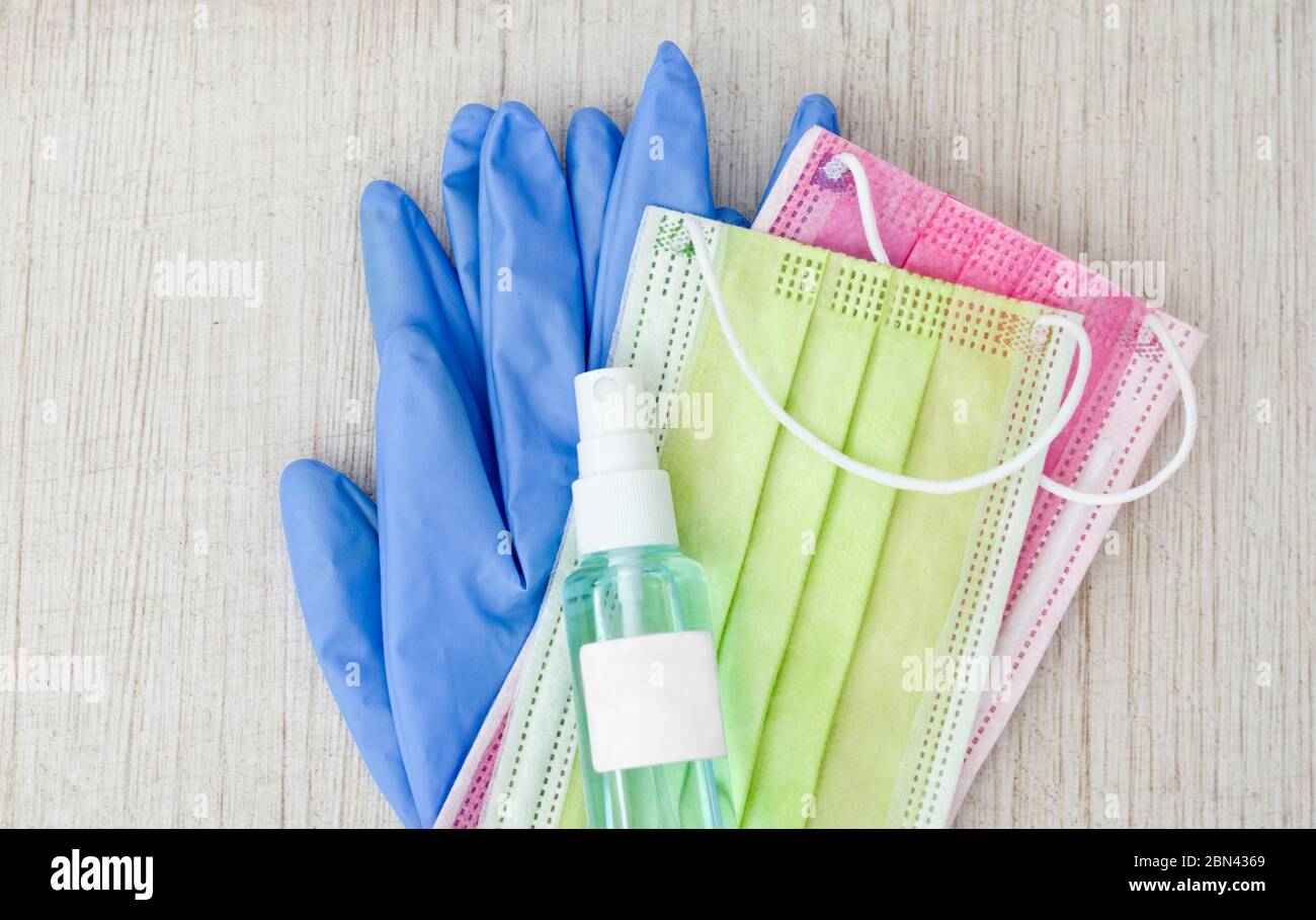 Nahaufnahme von OP-Handschuhen, Gesichtsmaske und Alkohol-Desinfektionsmittel Spray . Konzept zum Schutz und zur Vorbeugung der Ausbreitung von Bakterien und vi Stockfoto