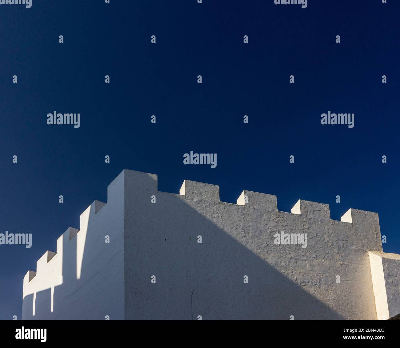 Morgenlicht beleuchtet die Zinnen, weiß getünchten Wände von Gebäuden in Asilah, Marokko Stockfoto