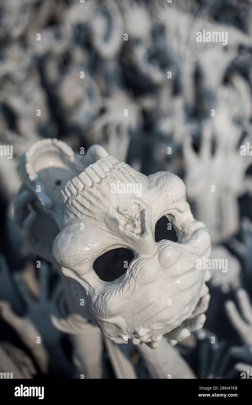 Skulptur eines Schädels auf einem Meer von Händen im weißen Tempel des Wat Rong Khun, Chang Rai, Thailand. Stockfoto