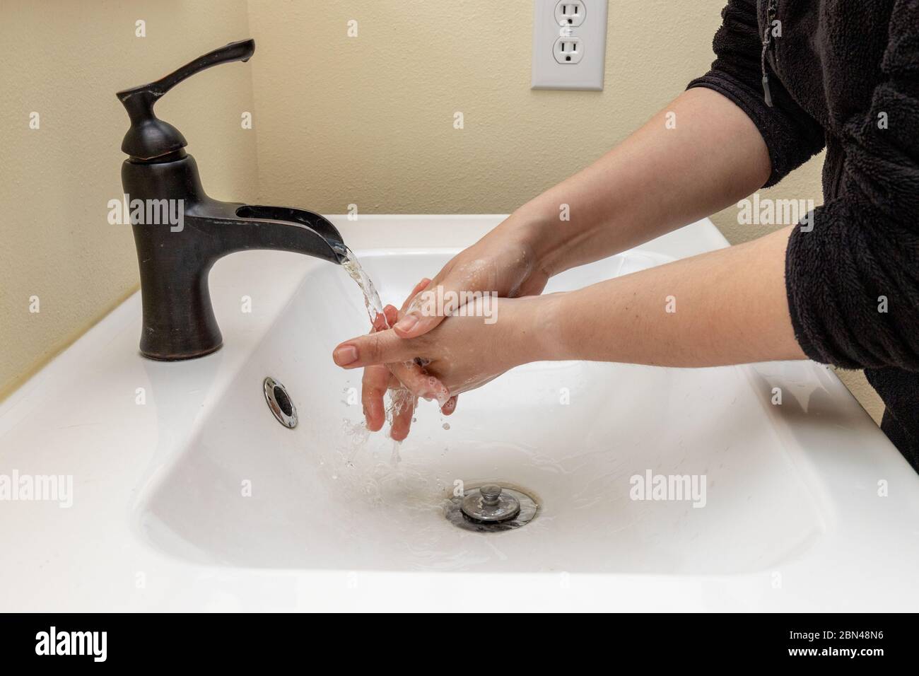 Weibliche Hände waschen zwischen den Fingern an den Händen zum Schutz vor Keimen Stockfoto