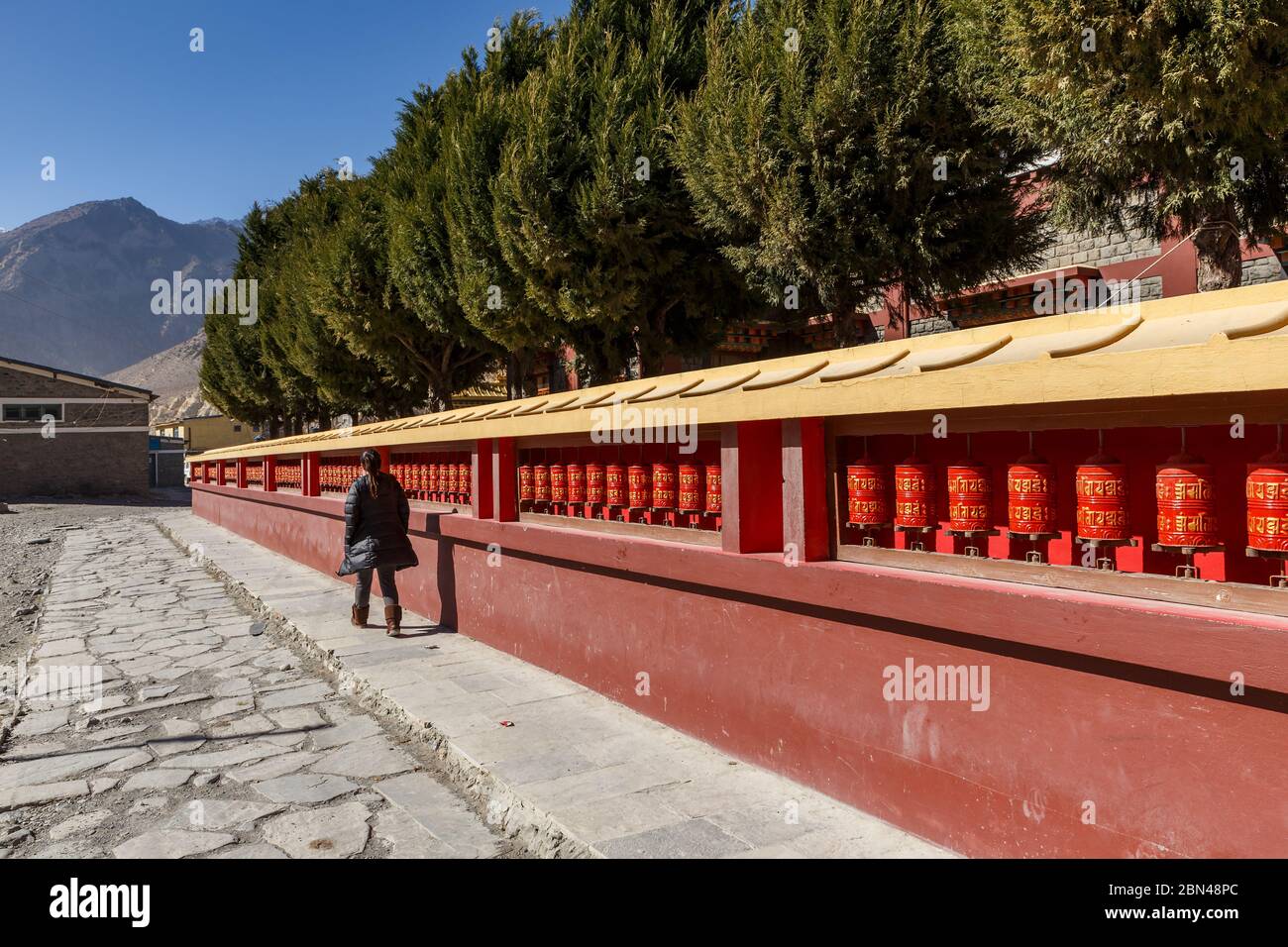 Eine Frau spinnt buddhistische Gebetstrommeln. Buddhistischer Tempel in Jomsom. Nepal. Stockfoto