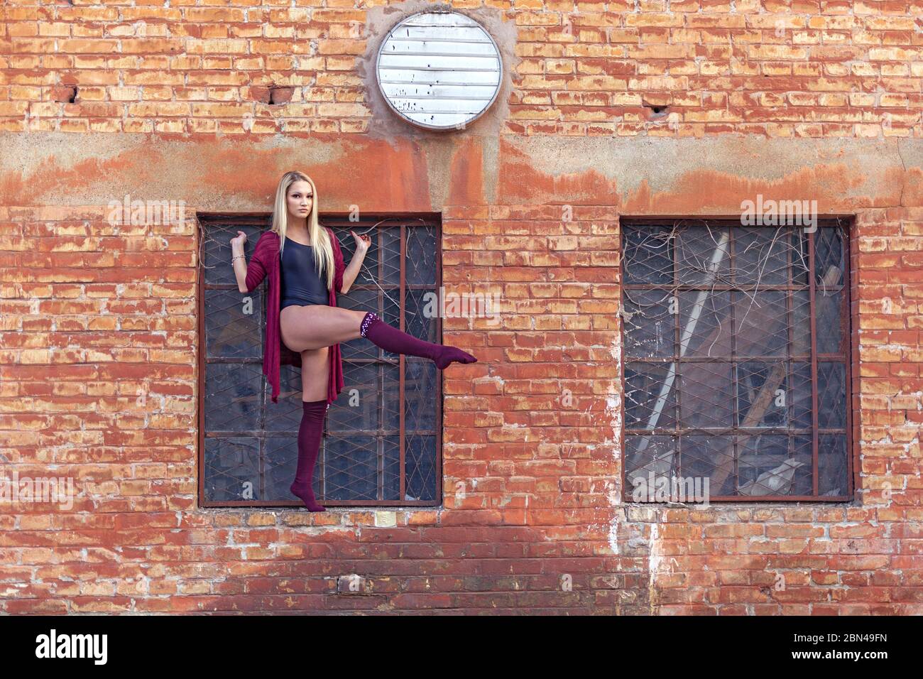 Tanzfrau posiert mit Fenster in der Altstadt Stockfoto