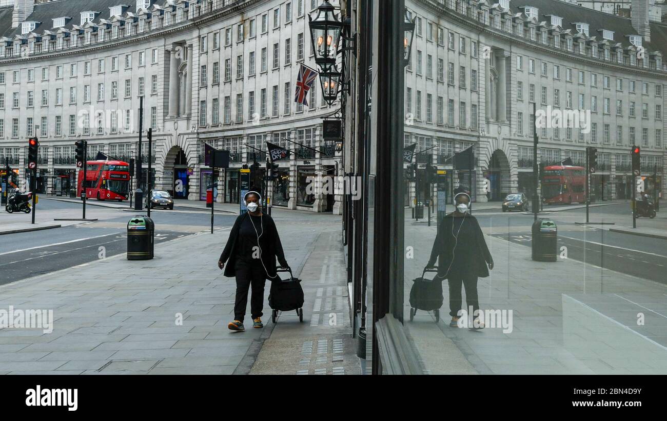 London, Großbritannien. 12 Mai 2020. Eine Frau trägt während der andauernden Sperrung der Coronavirus-Pandemie im Zentrum Londons eine Facemask. Die britische Regierung empfiehlt das Tragen von Gesichtsbezügen als Rückkehr der Öffentlichkeit in die Arbeit in Bereichen, in denen soziale Distanz nicht aufrechterhalten werden kann, und in öffentlichen Verkehrsmitteln. Kredit: Stephen Chung / Alamy Live News Stockfoto