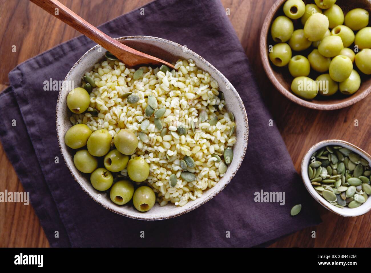 Bulgur mit grünen Oliven und Pepitas, gesunde Ernährung einfach Rezept aus lange gelagerten Lebensmitteln. Stockfoto