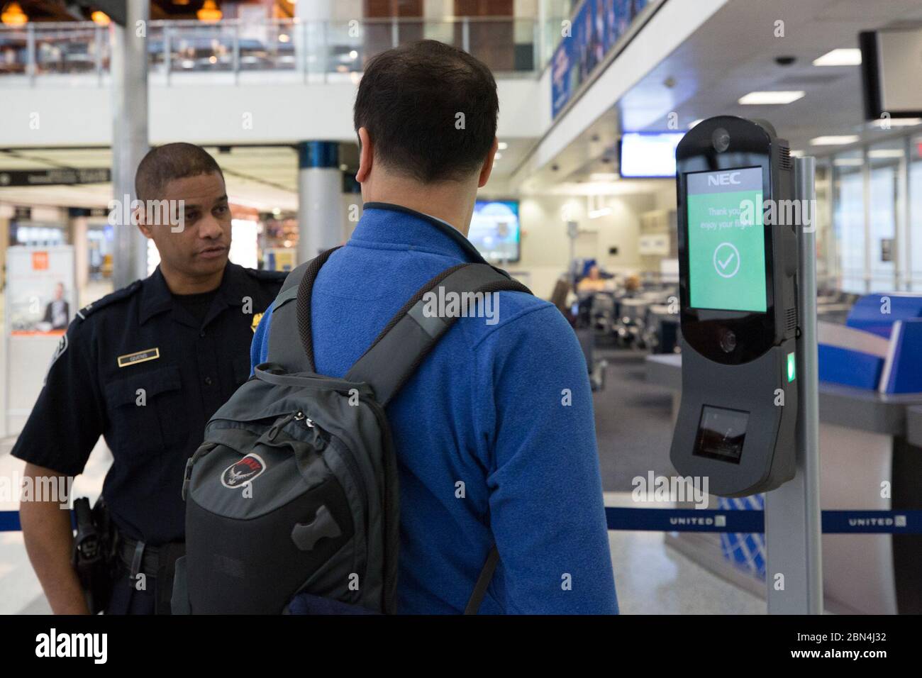Am 12. Februar 2018 half ein US-Zoll- und Grenzschutzbeamter am Houston International Airport einem Passagier beim Ticketscannen und der biometrischen Gesichtserkennung beim Boarding. Dieser Prozess ist Teil der Bemühungen zur Verbesserung der Flughafensicherheit. Stockfoto
