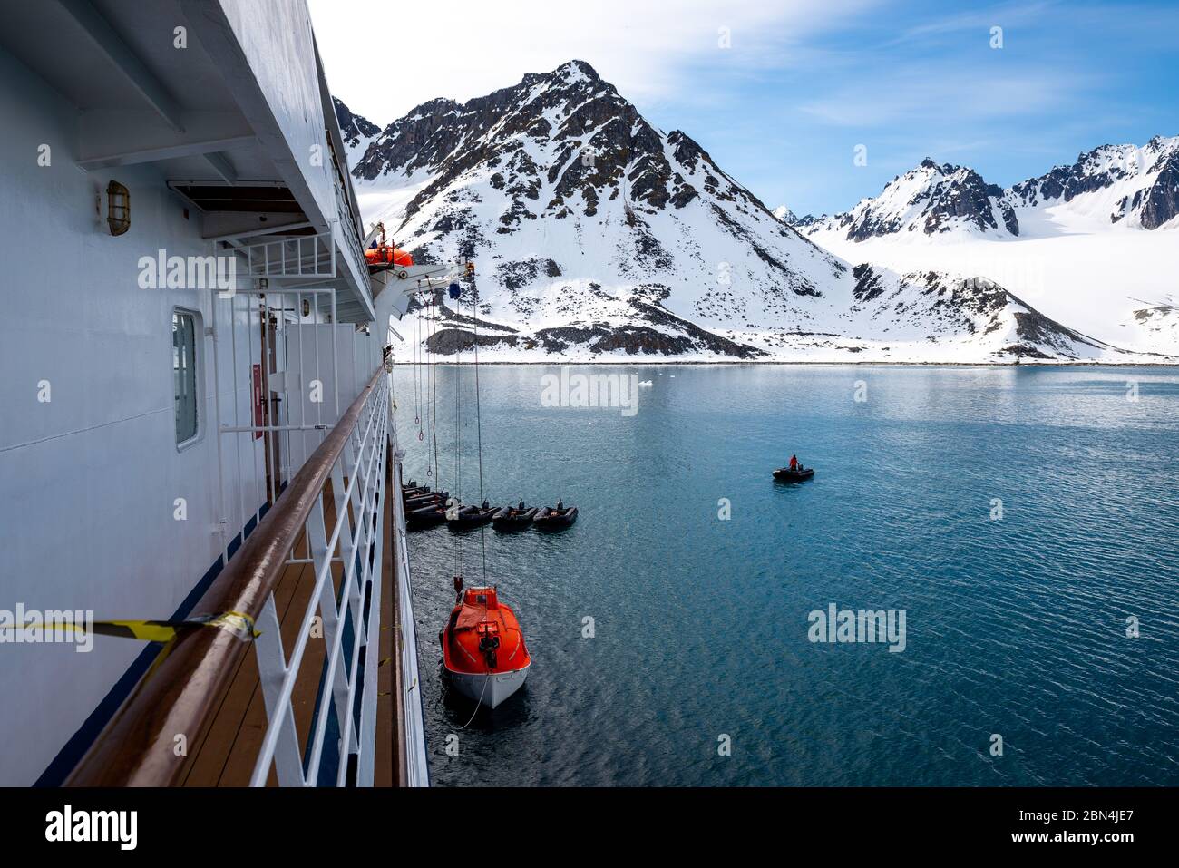 Das orangefarbene Rettungsboot in arktischen Gewässern, Spitzbergen, ins Wasser lassen. Schiffsangebohrung abbrechen. Rettungsboot-Training. Mann über Bord Bohrer. Stockfoto