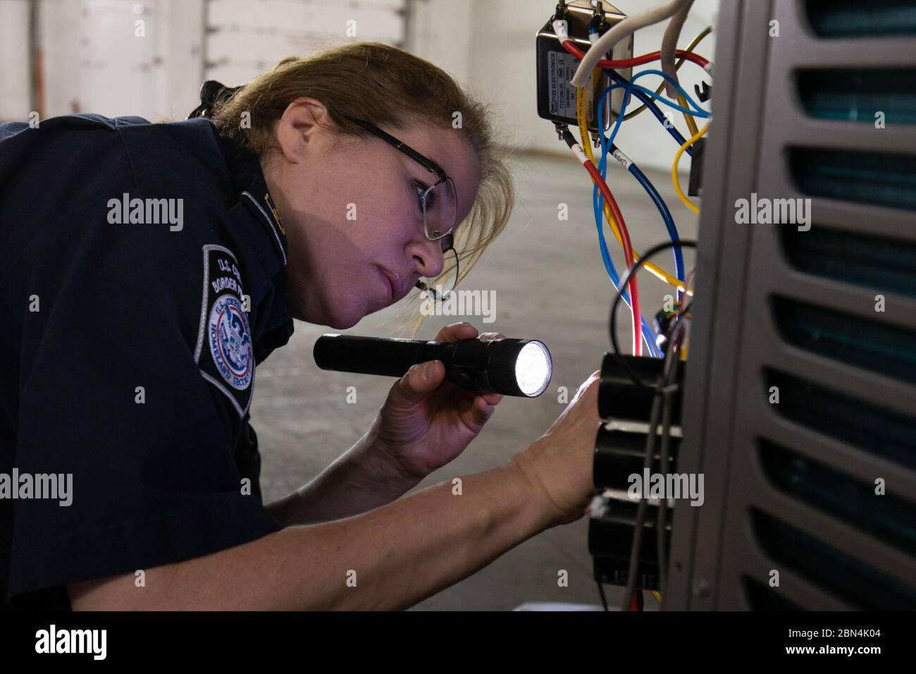 Zoll- und Grenzschutzbeamte und Importspezialisten, die dem Gebiet Port of Jacksonville zugewiesen sind, überprüfen Sendungen von möglichen Verletzungen der geistigen Eigentumsrechte am 21. Februar. Stockfoto