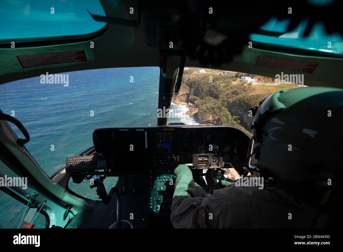 Die Ufer von Puerto Rico sind durch das Cockpit-Fenster eines US-Zolls und Grenzschutz Luft-und Seebetrieb AS350 A-Star Hubschrauber aus Aguadilla, Puerto Rico, 3. April 2019 gesehen. US-Zoll und Grenzschutz Stockfoto