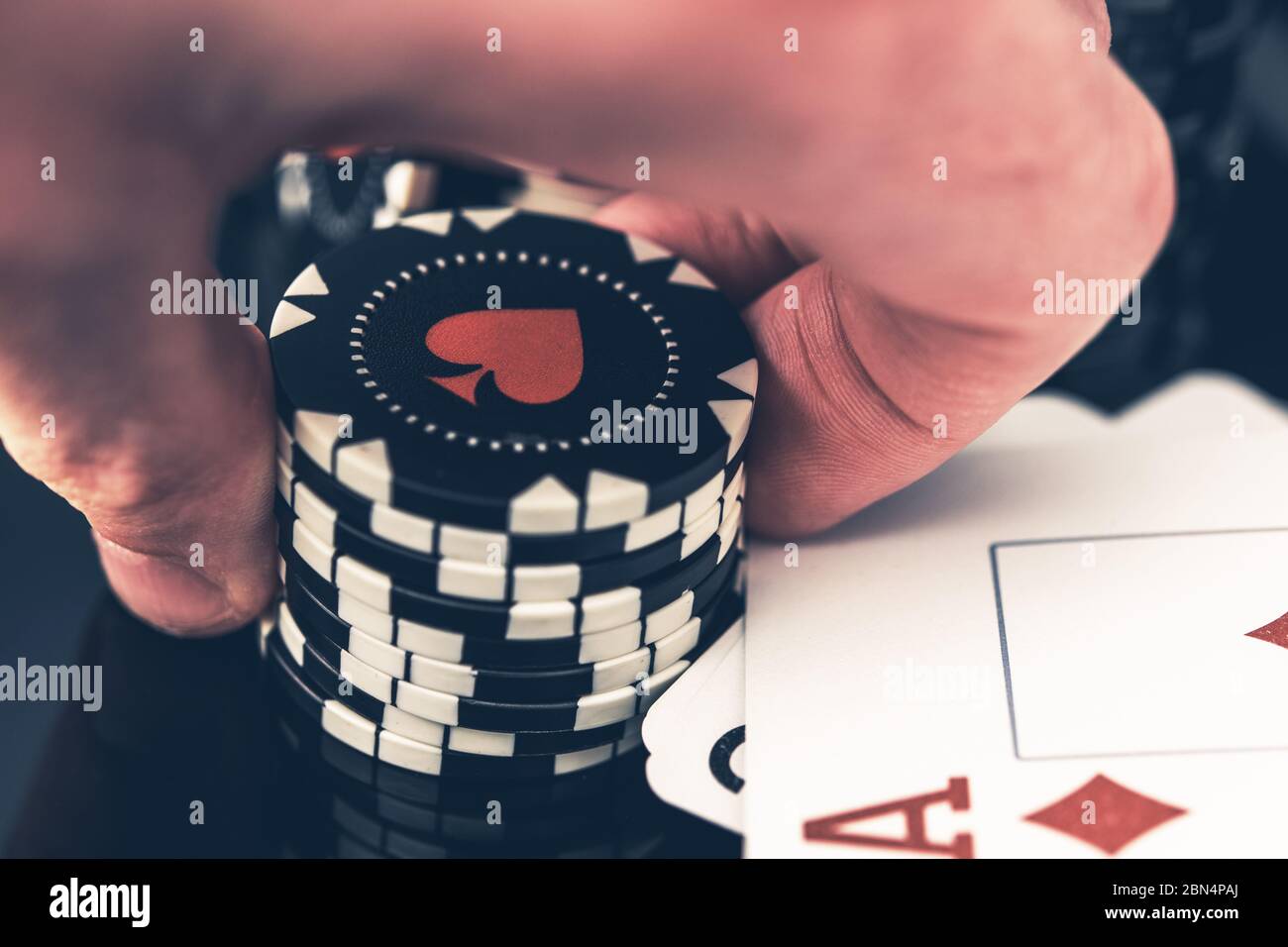 Nahaufnahme Von Man Holding Stack Of Poker Chips In Der Hand Mit Gewinnkarten Auf Dem Tisch Und Diamant Ass An Der Spitze. Stockfoto