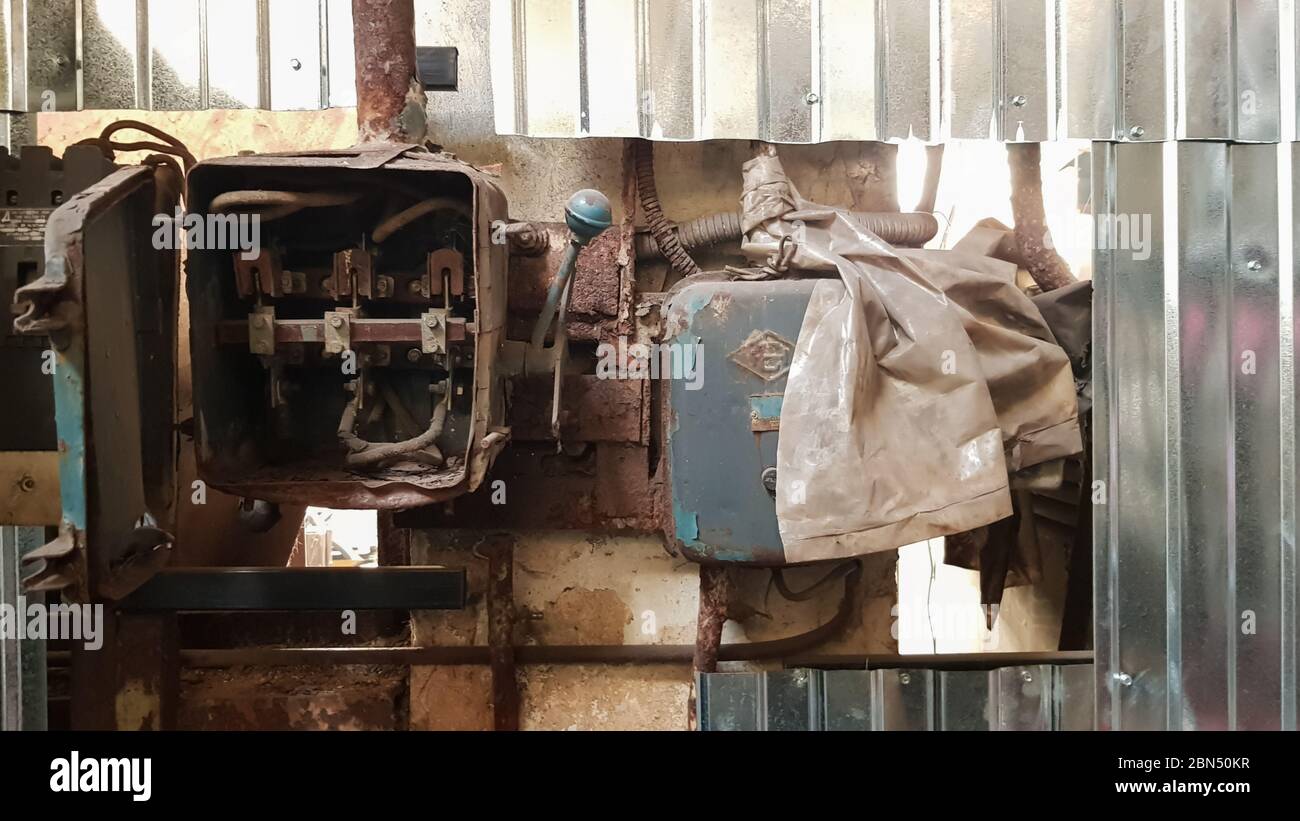 Alte zerlegte und rostige elektrische Schutzscheibe in einer verlassenen Fabrik vor dem Hintergrund des Chaos Stockfoto