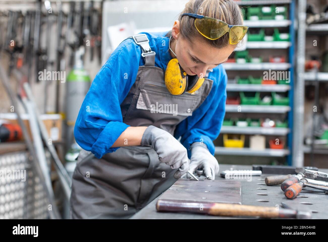 Seitenansicht des Arbeitnehmers Frau Kennzeichnung Stück Metall Stockfoto