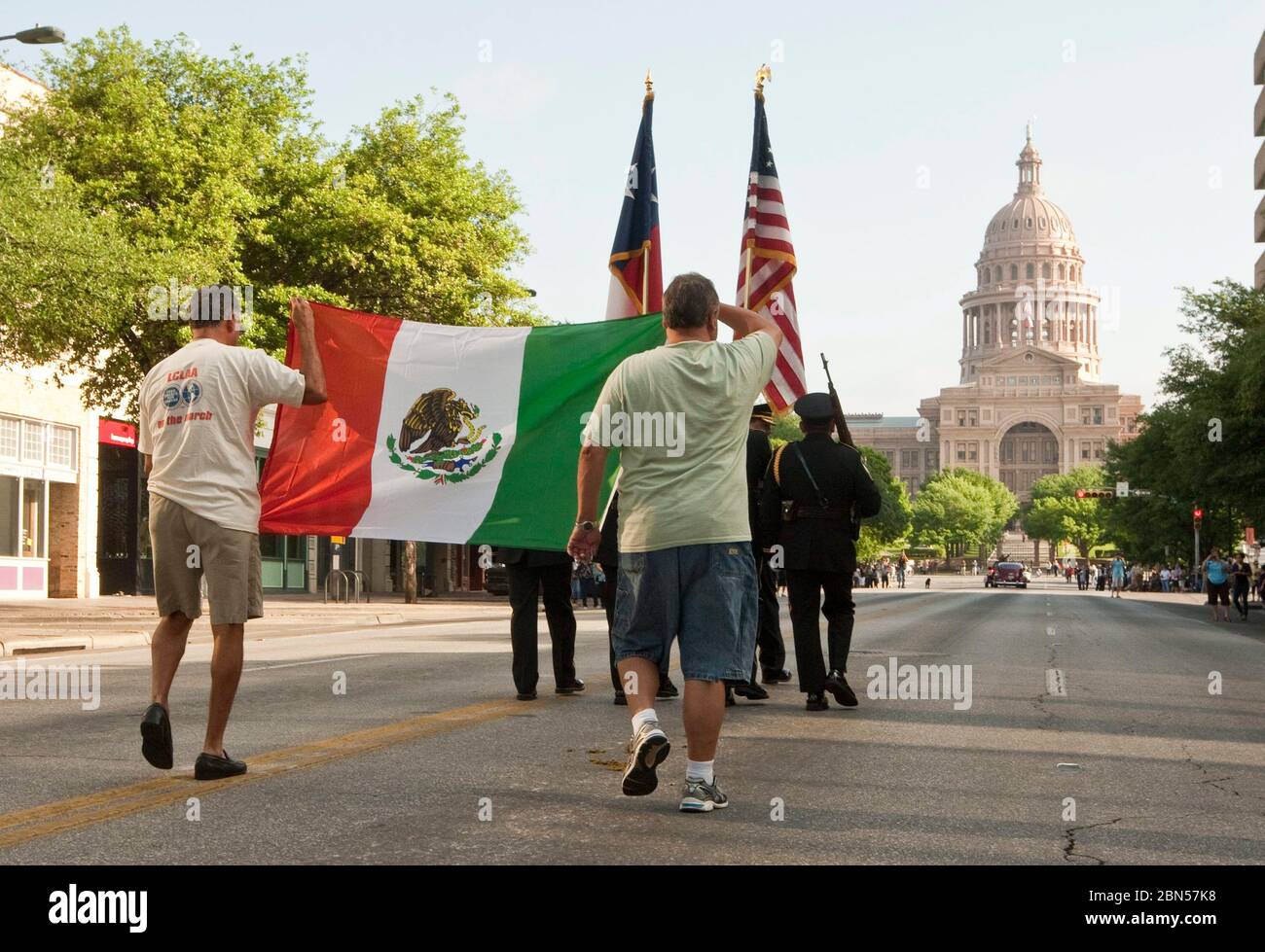 Austin Texas USA, März 2012: Männer tragen die mexikanische Flagge hinter den amerikanischen und texanischen Flaggen bei einer Parade auf der Congress Avenue, bei der die Enthüllung des Tejano Monument auf dem Gelände des Texas Capitol gefeiert wird. Das Denkmal ehrt die Beiträge von Tejanos, den spanischsprachigen Siedlern, die die Cowboy-Kultur in den Staat brachten. ©Marjorie Kamys Cotera/Daemmrich Photography Stockfoto