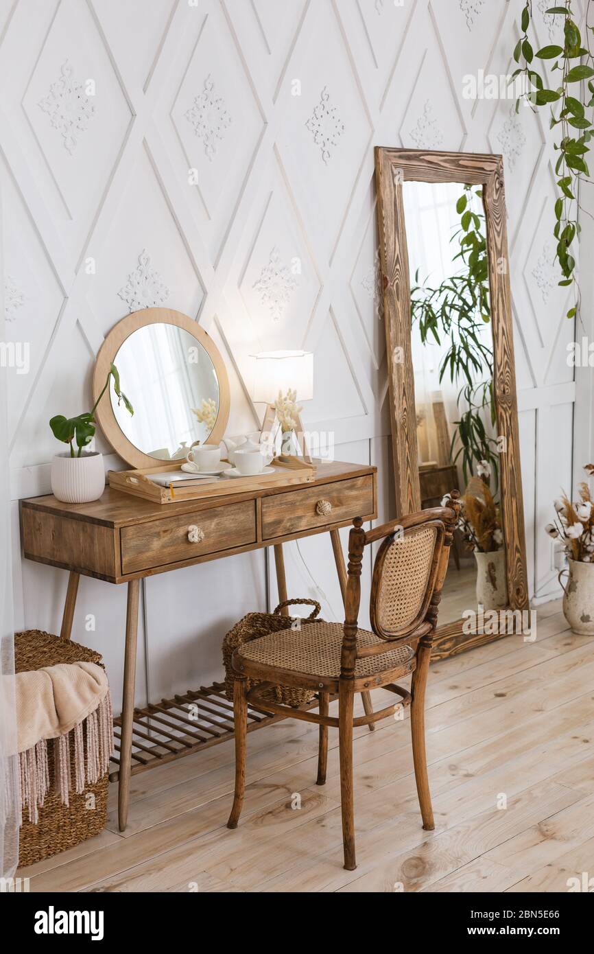 Weiblicher Tisch für Make-up im Schlafzimmer. Großer Spiegel und Holzmöbel Stockfotografie