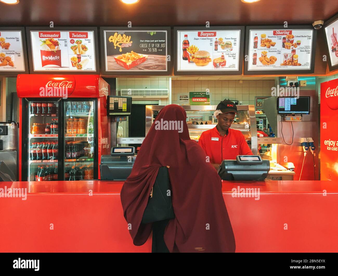 Eine Frau in einem Hijab gibt eine Fast-Food-Bestellung am KFC-Schalter in Nairobi, Kenia, auf Stockfoto