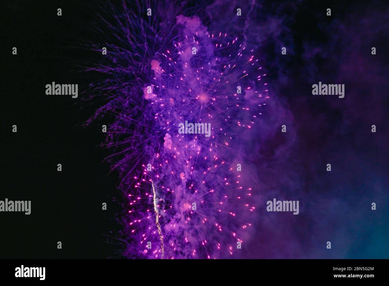Lila Feuerwerk mit Rauch über dem schwarzen Himmel. Geringe Tastenbelichtung. Selektiver Fokus. Stockfoto