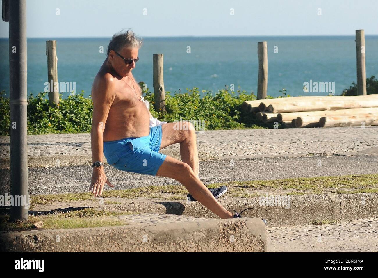 Rio de Janeiro, Brasilien, 11. Mai 2020. Älterer Mann ohne Schutzmaske während der COVID-19 Pandemie stolpert er und fällt auf den Bürgersteig Boden Stockfoto