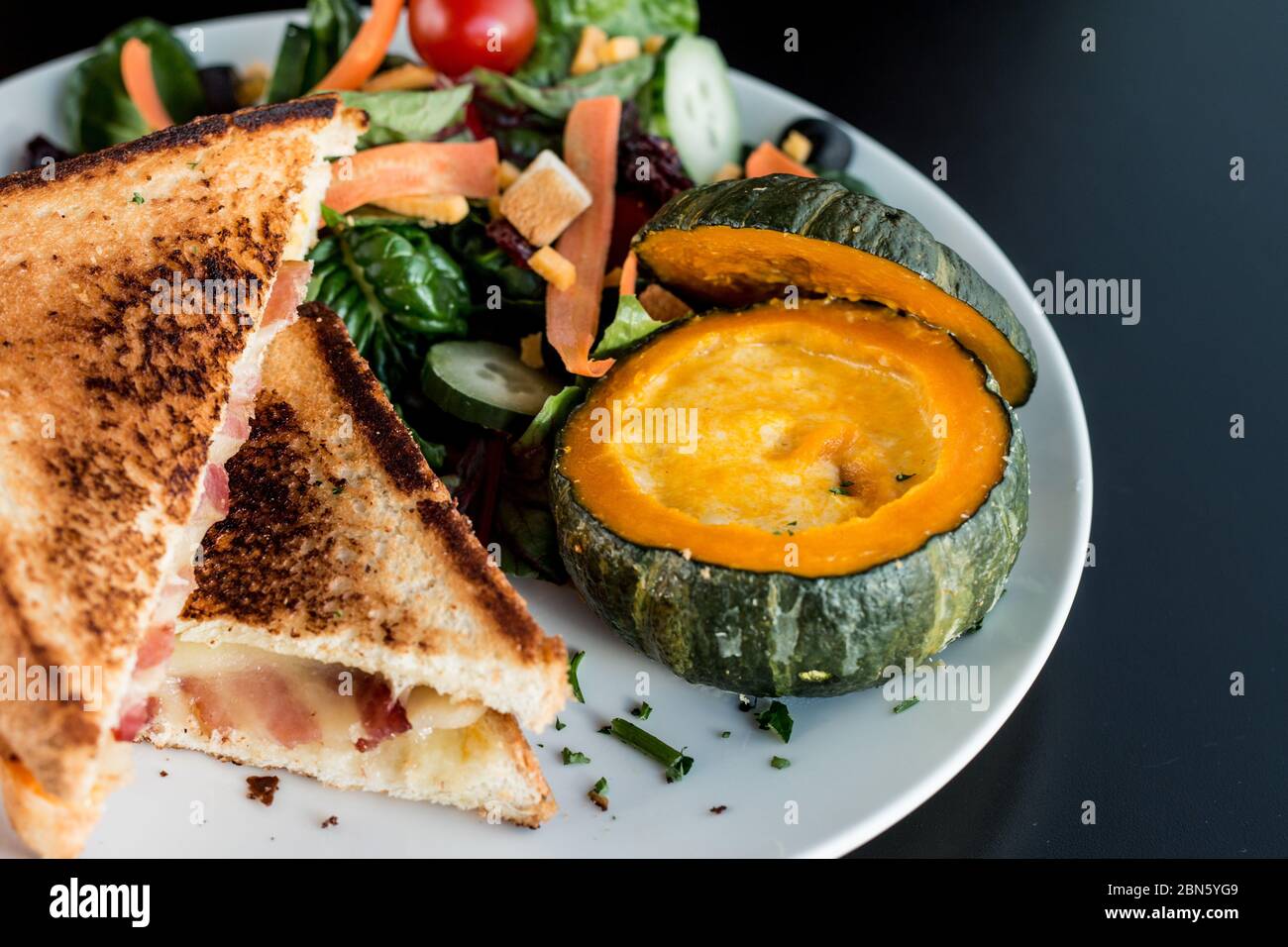 Draufsicht Bild von Käse Speck Toast Brot und Kürbissuppe in einem Mini Kürbisschale Stockfoto