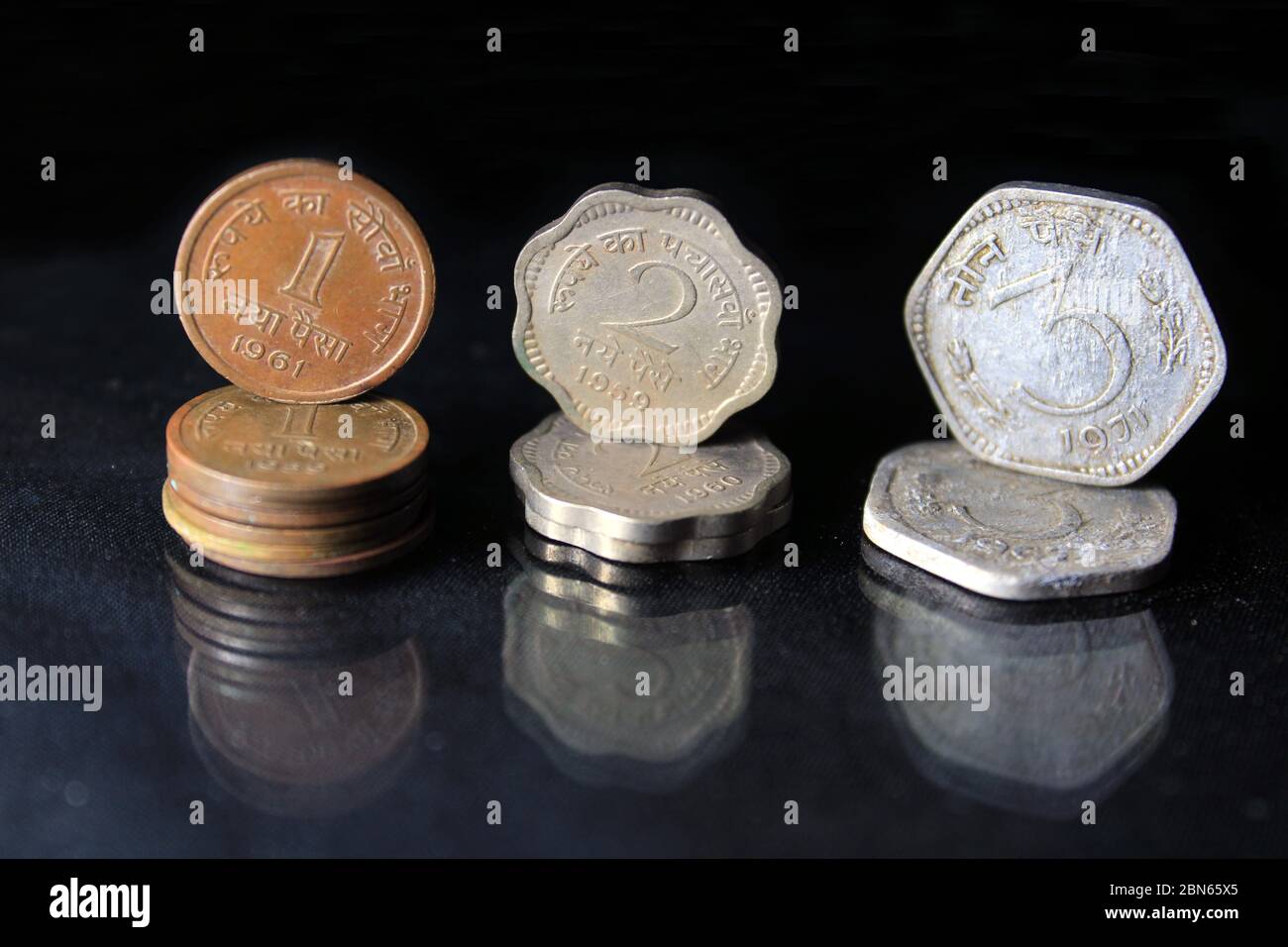 Eine alte indische, zwei- und drei Paisa-Münzen auf schwarzem Hintergrund. Eine alte antike indische Paise Münzen. Stockfoto