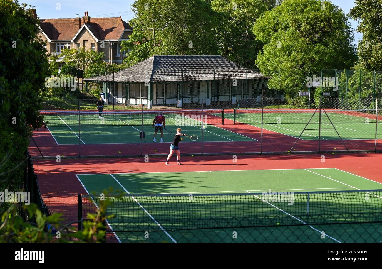 Brighton UK 13. Mai 2020 - Tennisspieler nehmen an den Plätzen im Queens Park Brighton früh am Morgen nach der Lockerung einiger Coronavirus Lockdown Maßnahmen in England. Einige Lockdown-Maßnahmen wurden in England von Boris Johnsons Regierung gelockert, einschließlich Tennis oder Golf während der Coronavirus COVID-19 Pandemie. : Credit Simon Dack / Alamy Live News Stockfoto