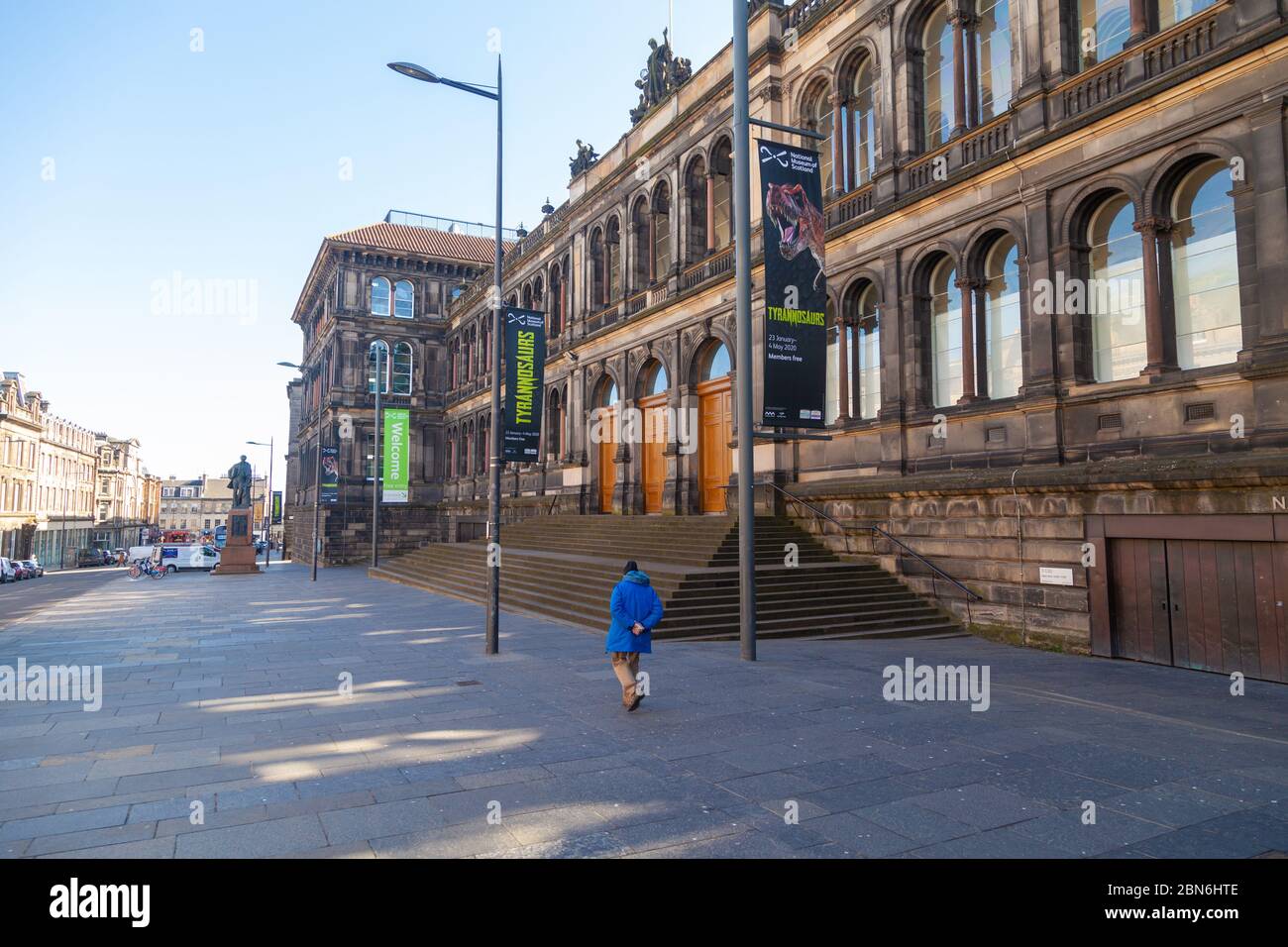 Ein einsamer Tourist, der am Nationalmuseum schottland auf der Chambers Street vorbeiläuft, kurz bevor die Sperrung durchgesetzt wurde. Stockfoto
