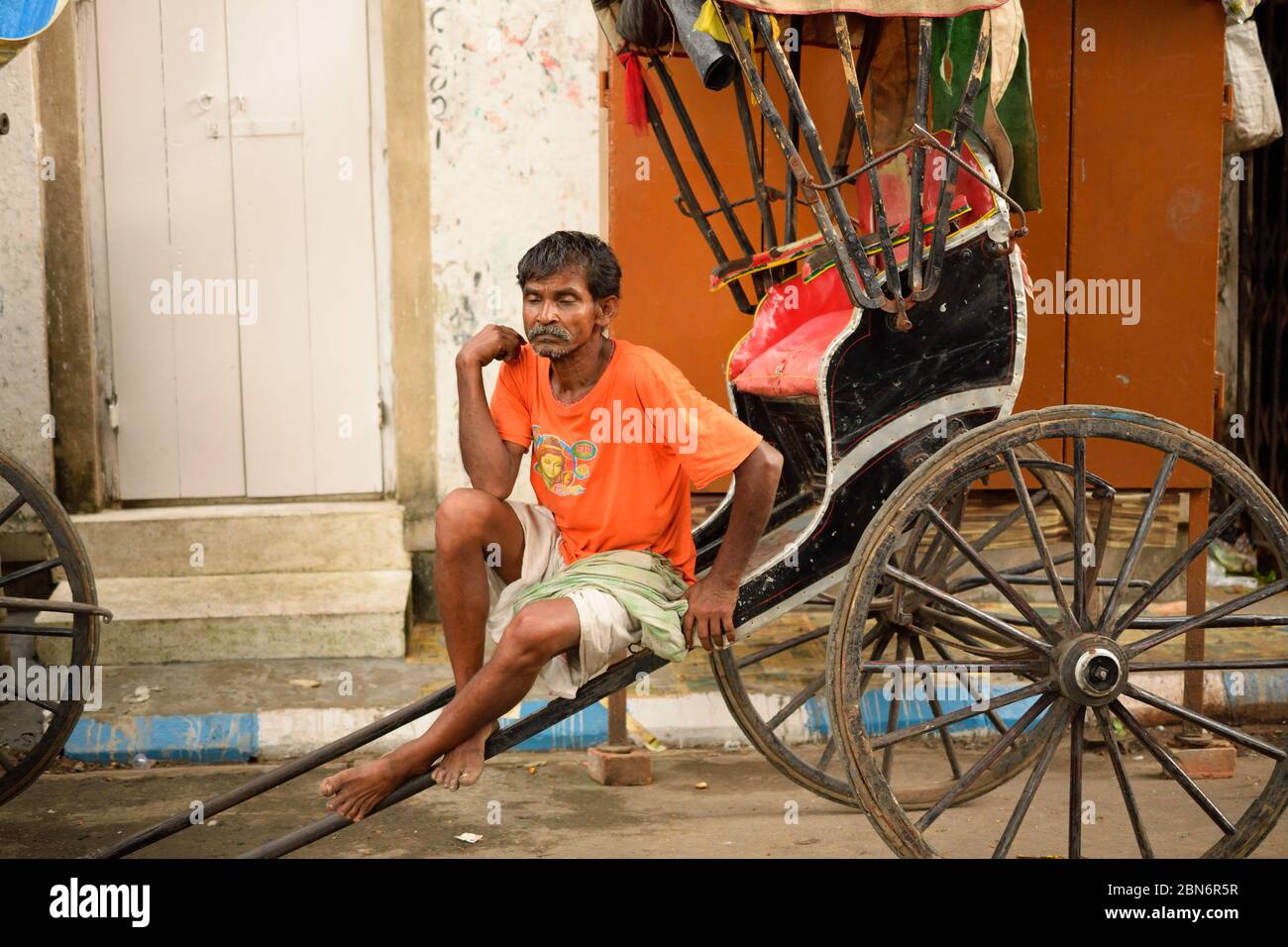 Kolkata, Indien - 1. Oktober 2016: Ein Handrickshaw-Abzieher wartet auf Passagiere in seiner Rikscha. Stockfoto