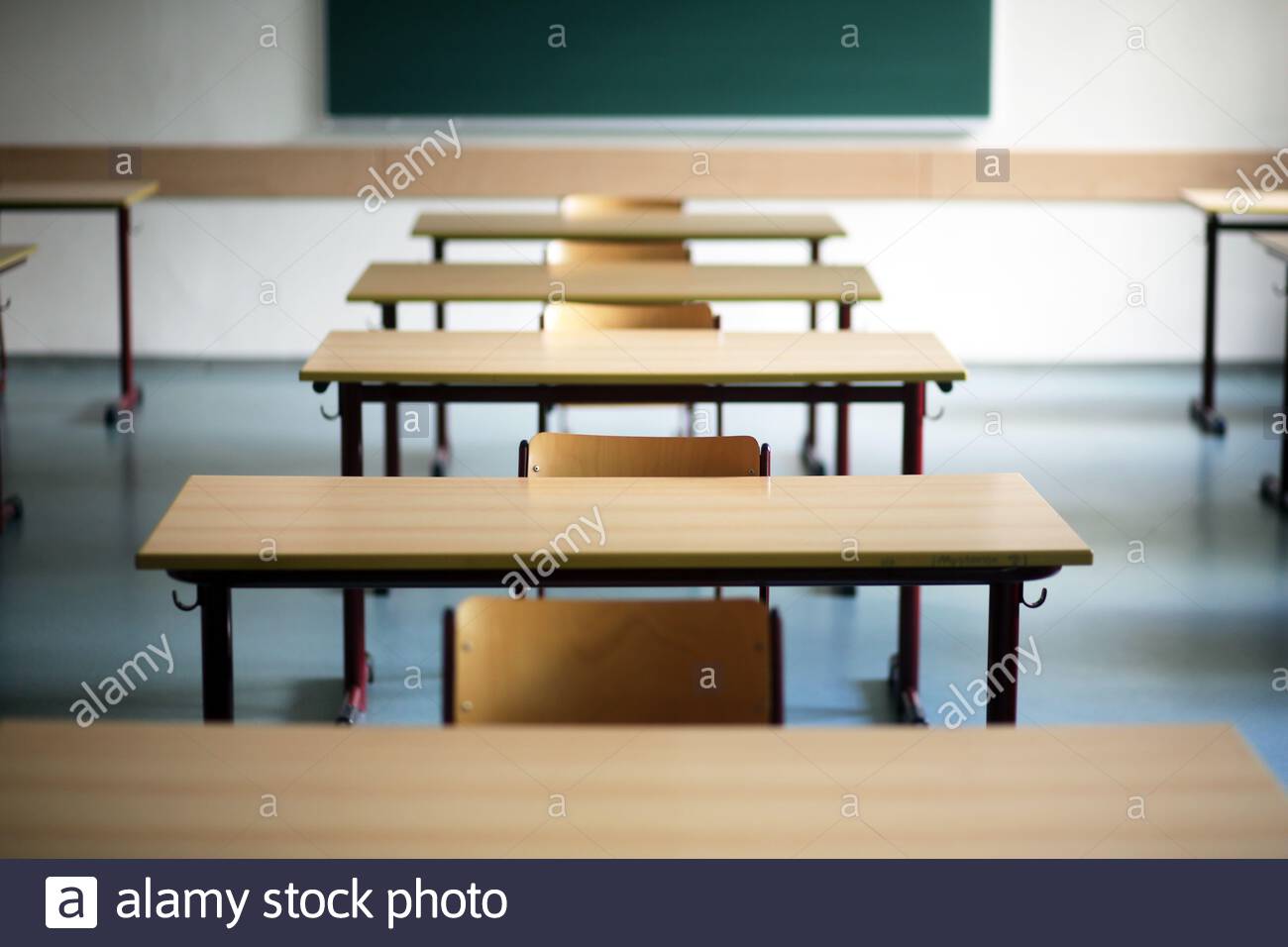 Ein Satz von Schulschreibtischen und Stühlen in einem leeren Klassenzimmer in Deutschland während der Corona-Krise. Stockfoto