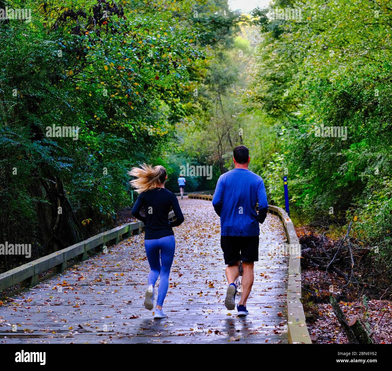 Paar laufen auf dem Wet Trail Stockfoto