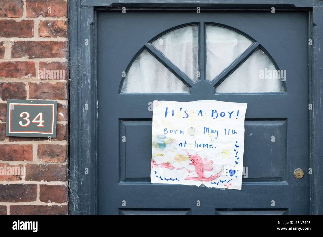 Ankündigung der Geburt eines neuen Babys, das während der Sperrung der Coronavirus-Pandemie an eine Haustür in einer kleinen britischen Stadt geflemmt wurde Stockfoto