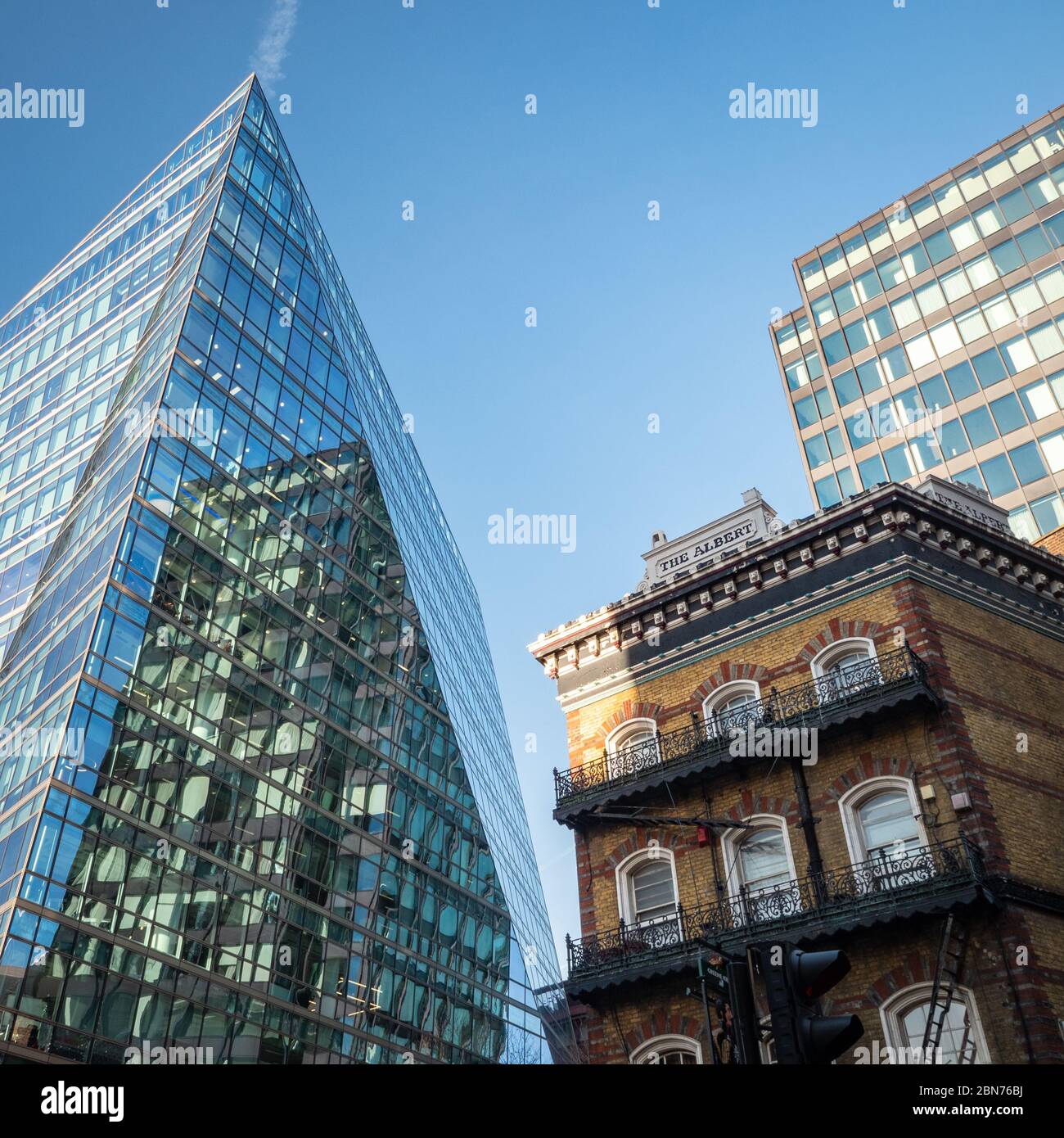 Alt und Neu. Kontrastierende architektonische Stile im Zentrum Londons mit einem abstrakten kantigen Büroblock, der sich gegen einen traditionellen alten Pub ansetzt. Stockfoto