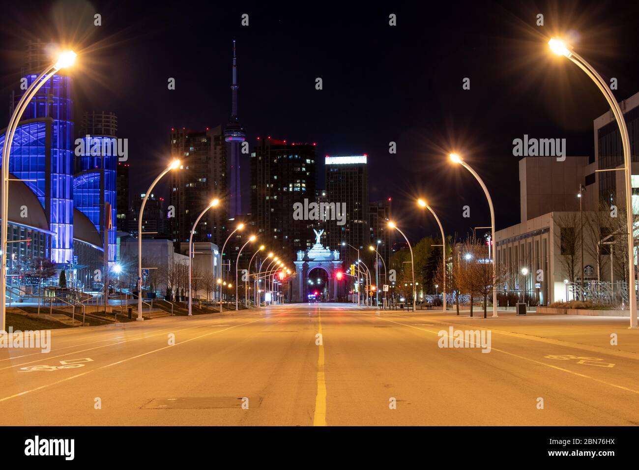 Leerer Princes' Boulevard in der Innenstadt von Toronto, das Enercare Center und Princes’ Gates in purpurem Licht für die Unterstützung während der COVID-19 Pandemie. Stockfoto